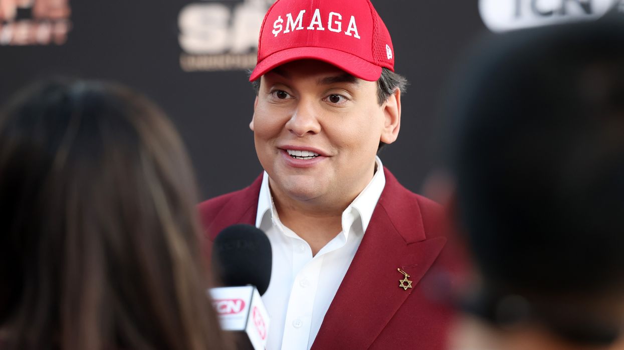 George Santos wears a hat reading "$MAGA"