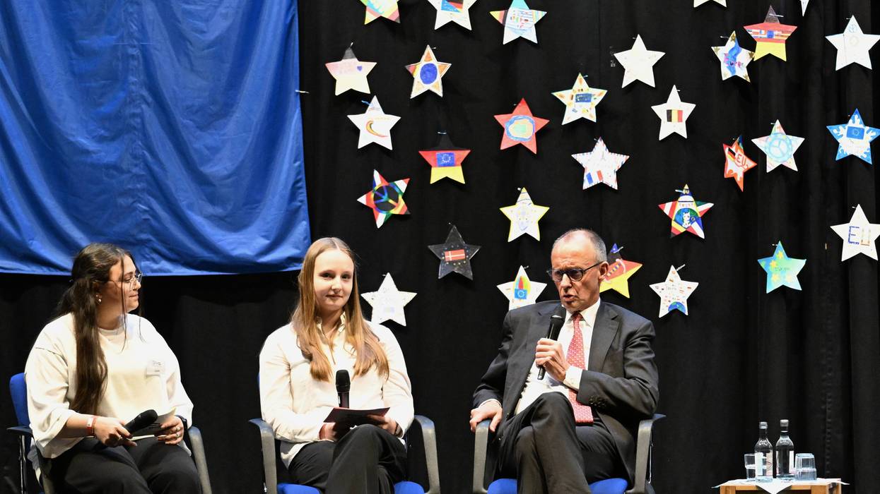 German Chancellor Friedrich Merz sits next to high school students