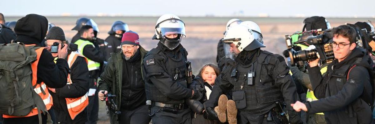 German police officers carry Swedish climate activist Greta Thunberg away from the edge of a coal mine in North Rhine-Westphalia, Germany on January 17, 2023.