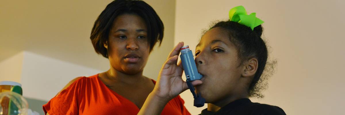 Girl with asthma takes her medication