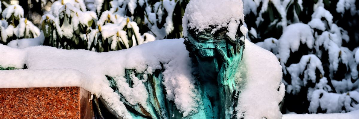 Green statue covered in snow