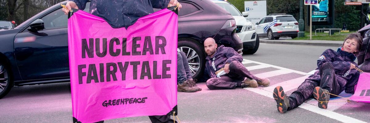 Greenpeace activist holds sign reading "Nuclear Fairy tale."