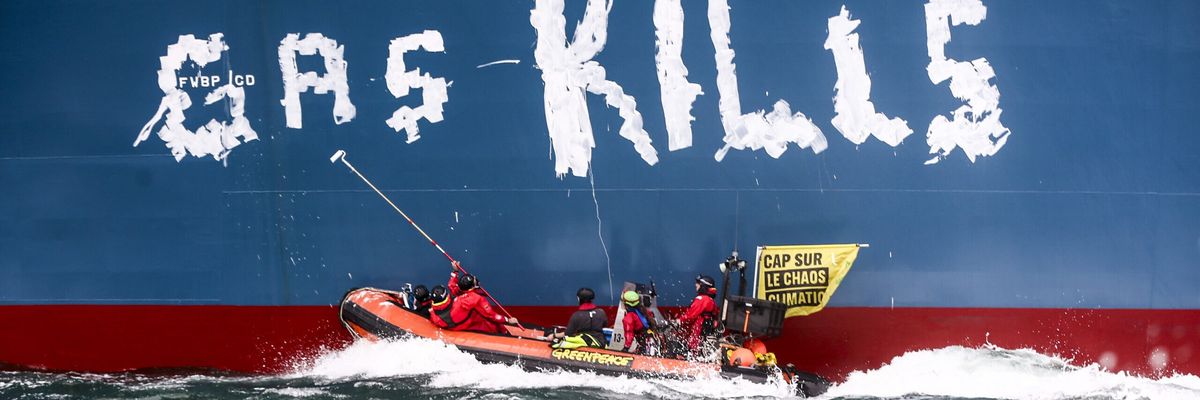 Greenpeace activists paint, "Gas kills," on the hull of the Cape Ann.