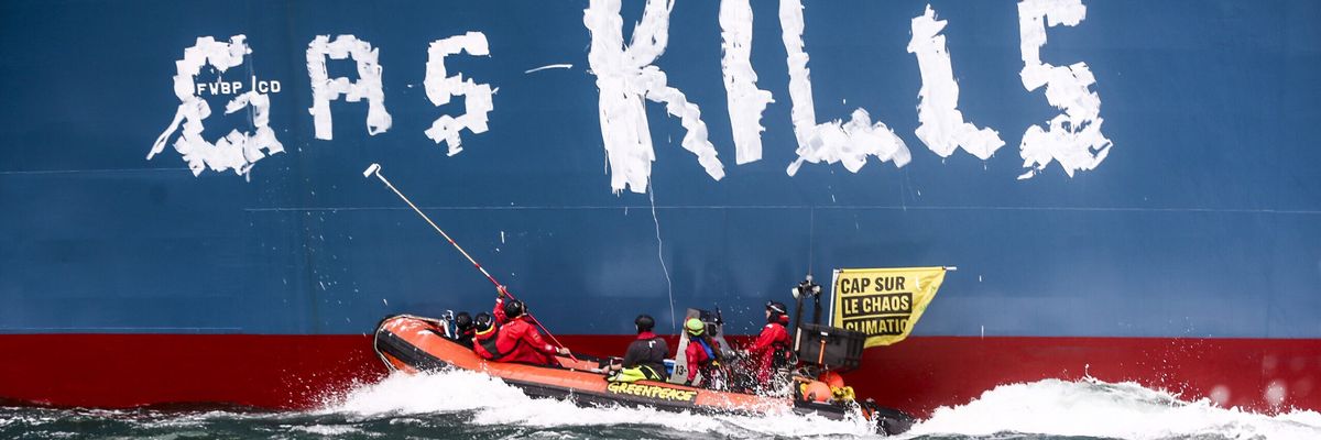Greenpeace activists paint, "Gas kills," on the hull of the Cape Ann.