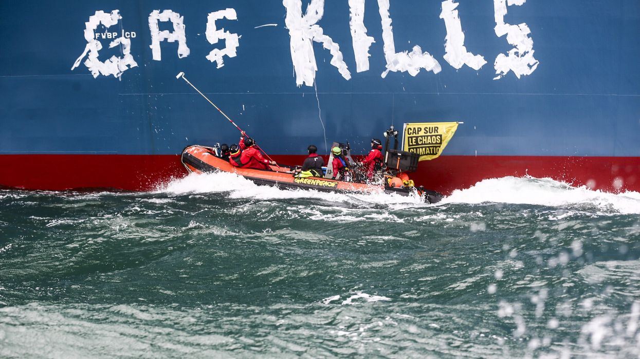 Greenpeace activists paint, "Gas kills," on the hull of the Cape Ann.