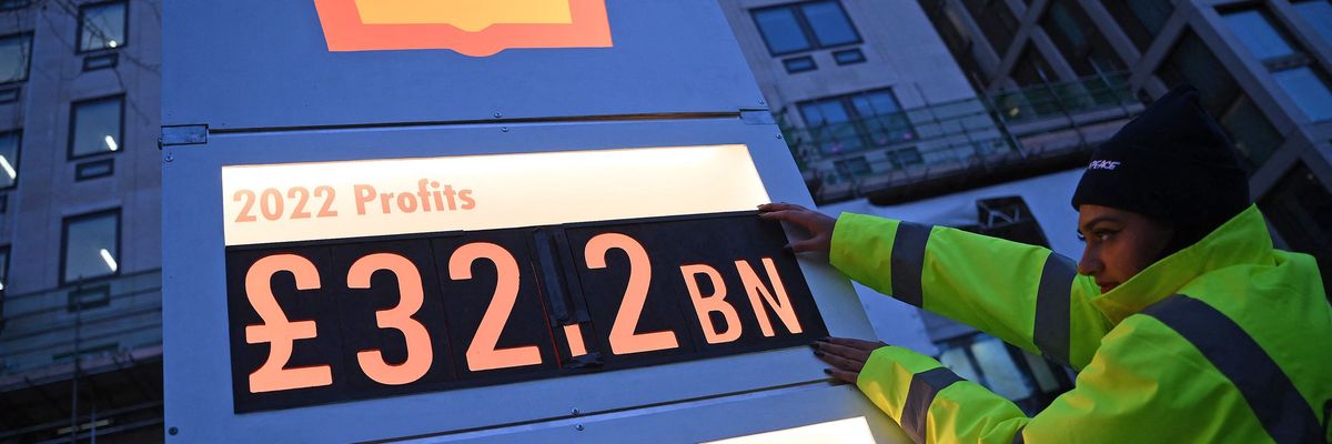 Greenpeace activists set up a mock gas station price board displaying Shell's net profit for 2022 outside of the company's headquarters in London
