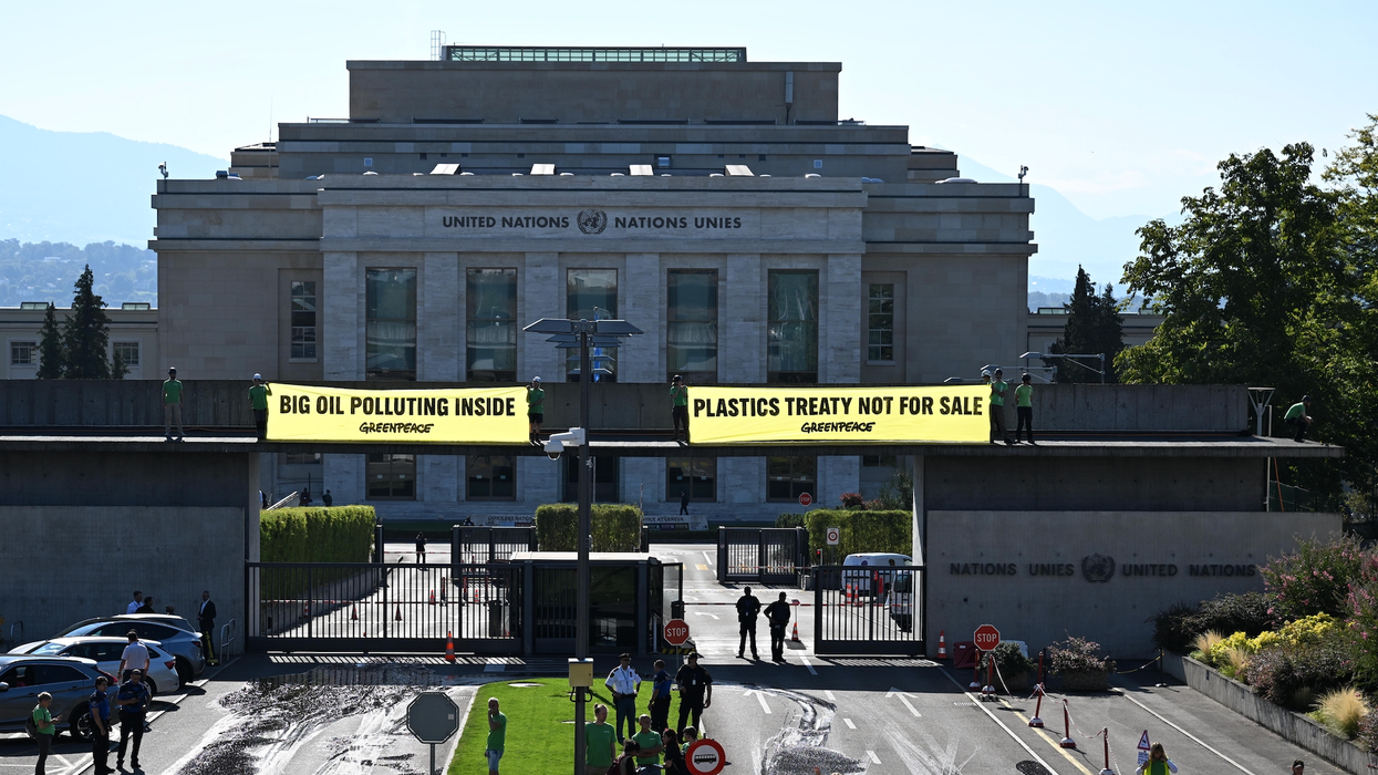 Greenpeace activists unfurl banners reading "Big Oil Polluting Inside" and "Plastics Treaty Not for Sale"