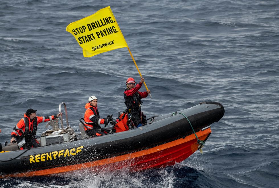 Greenpeace climate justice activists approach a Shell rig by boat