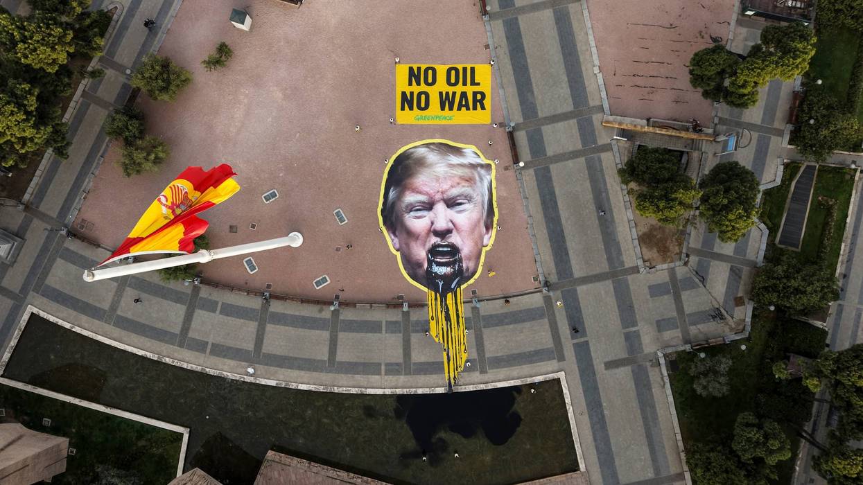 Greenpeace Spain activists displayed a giant image of US President Donald Trump vomiting oil