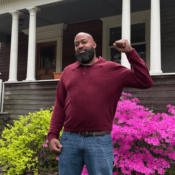 Greg Levy stands outside John Brown's house with his fist raised