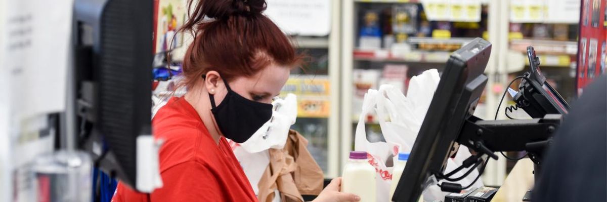 Grocery store employee wearing a mask.