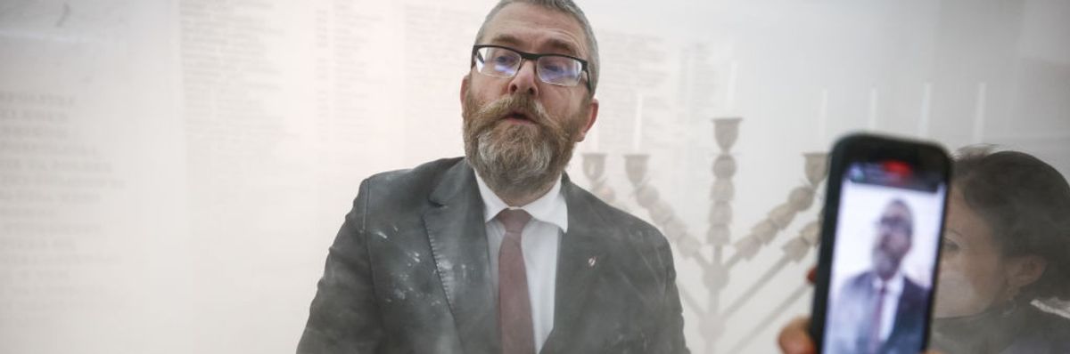 Grzegorz Braun after using fire extinguisher on menorah