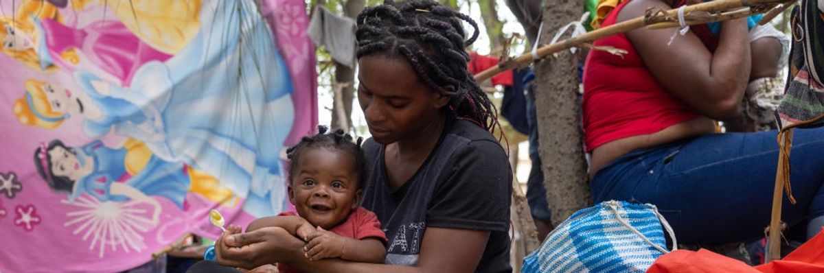 Haitian immigrant feeds her child