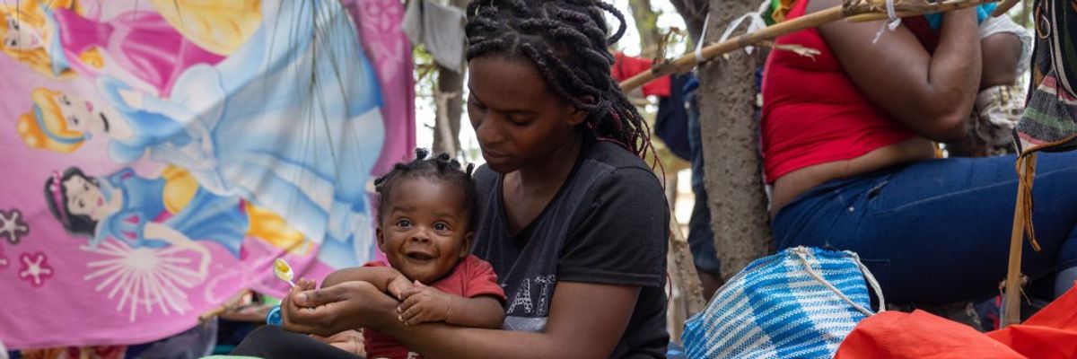 Haitian immigrant feeds her child