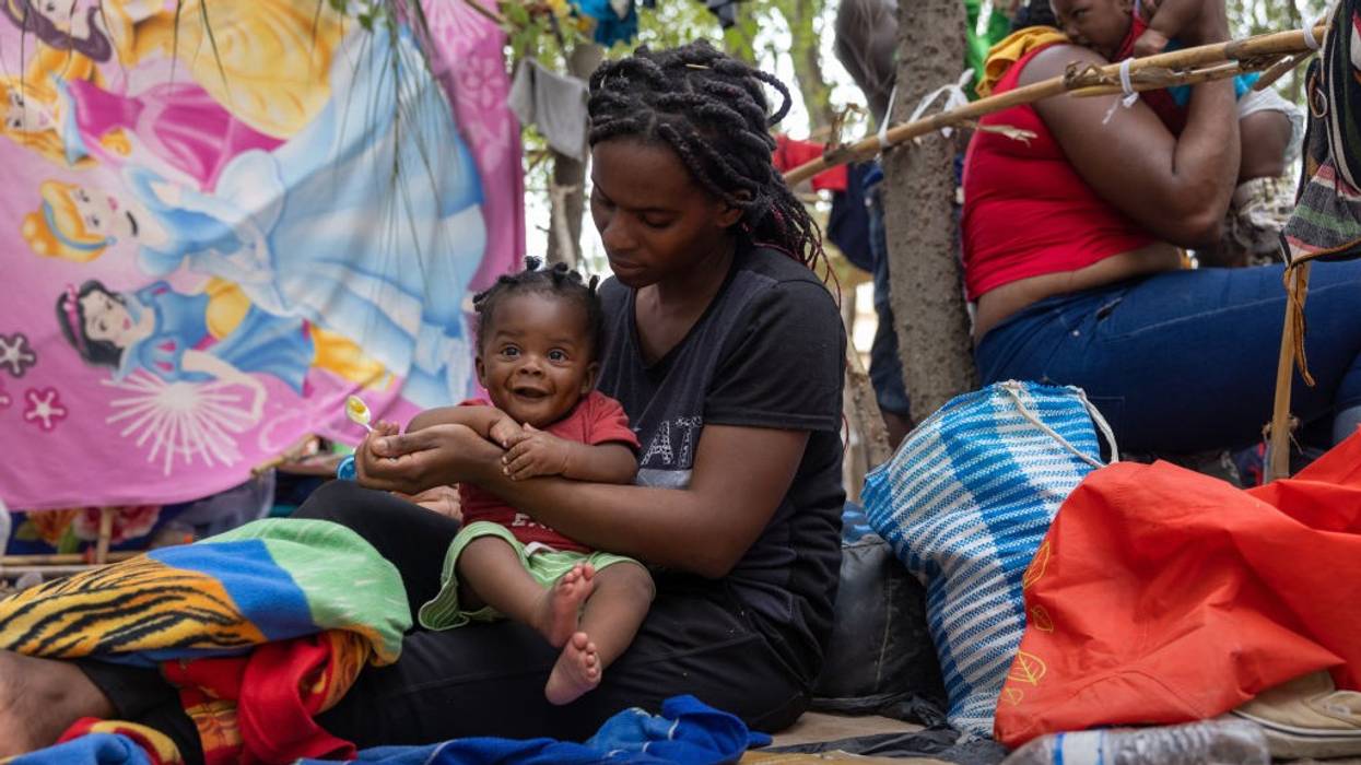 Haitian immigrant feeds her child