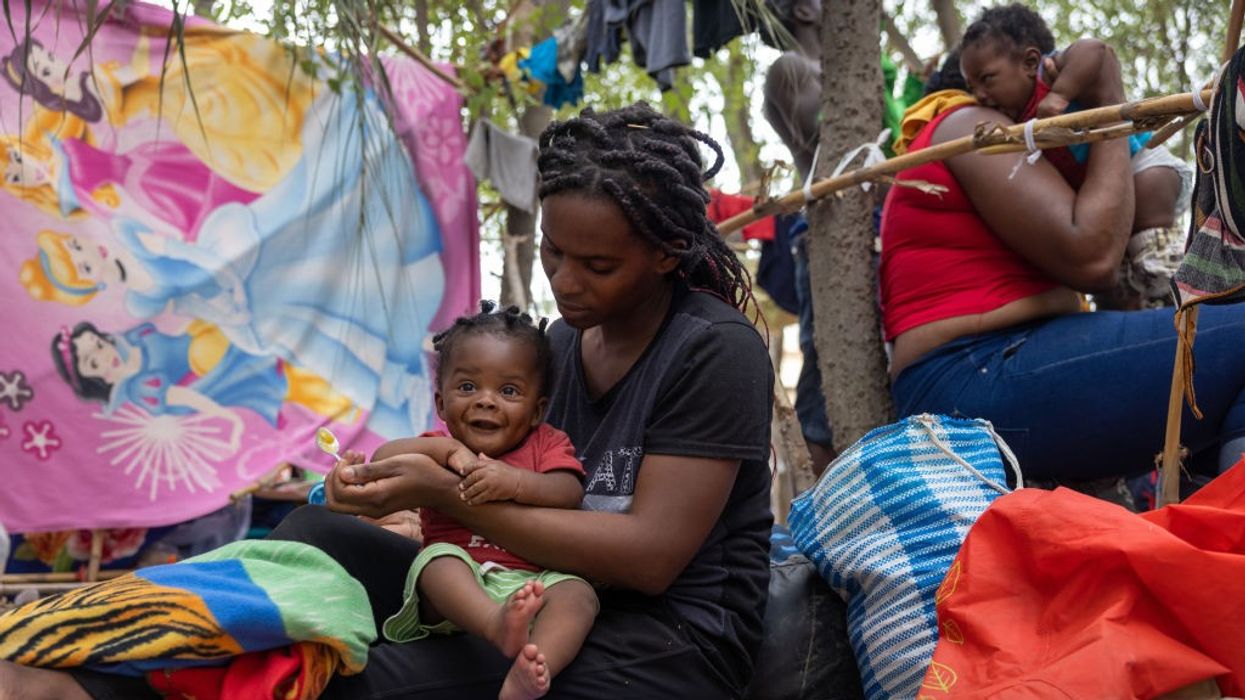 Haitian immigrant feeds her child