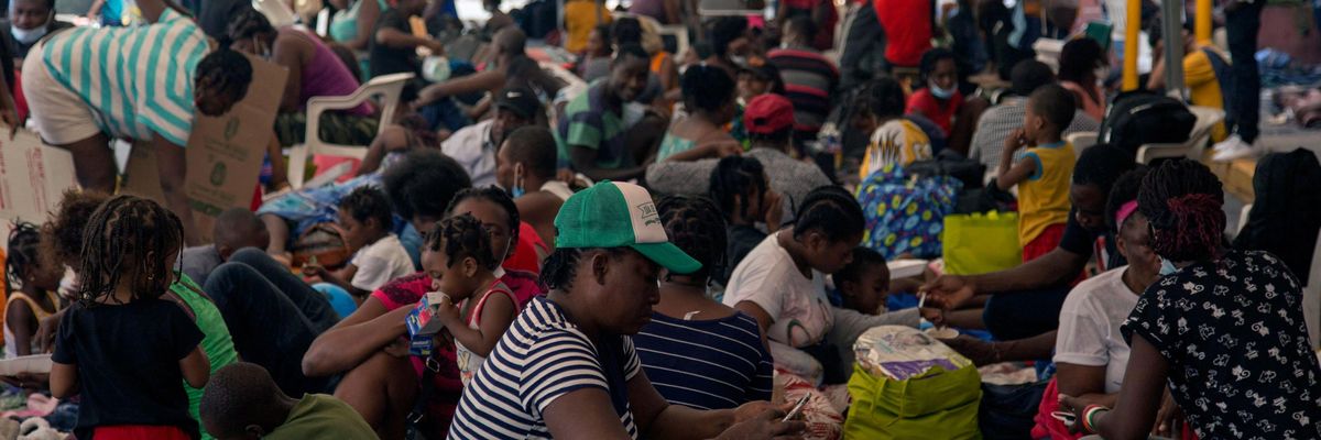 Haitian migrants remain outside a migrant shelter 