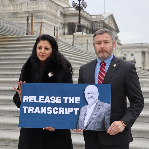 Hanan Elatr Khashoggi and Rep. Eugene Vindman stand outside the Capitol with a sign reading, "RELEASE THE TRANSCRIPT"