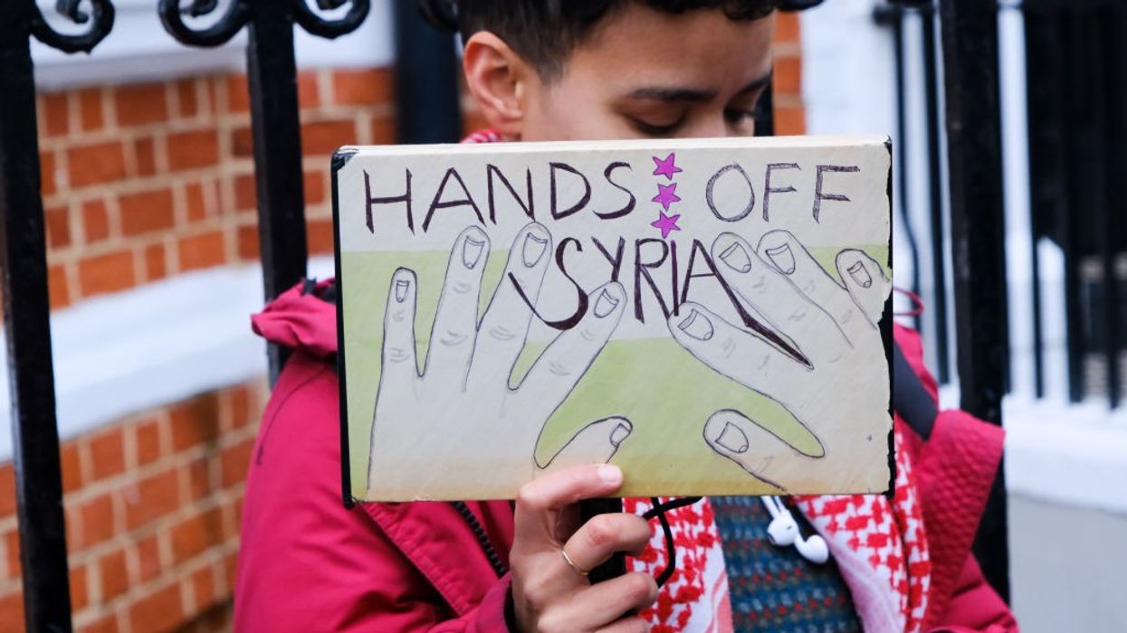 "Hands Off Syria," sign says