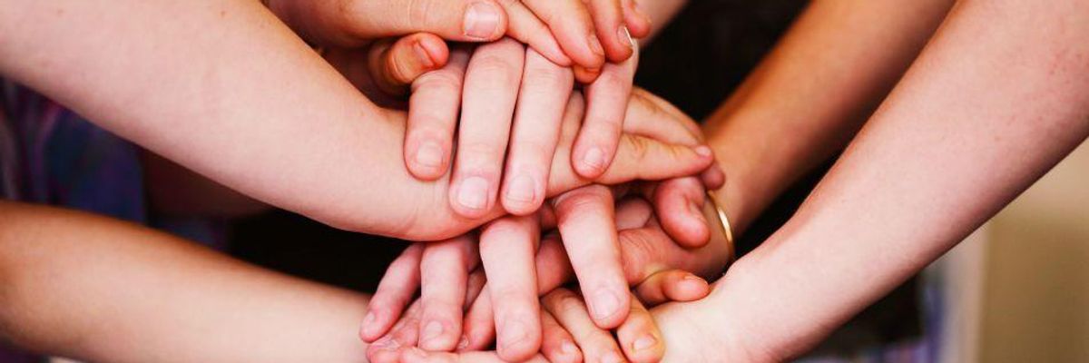 Hands on top of many hands