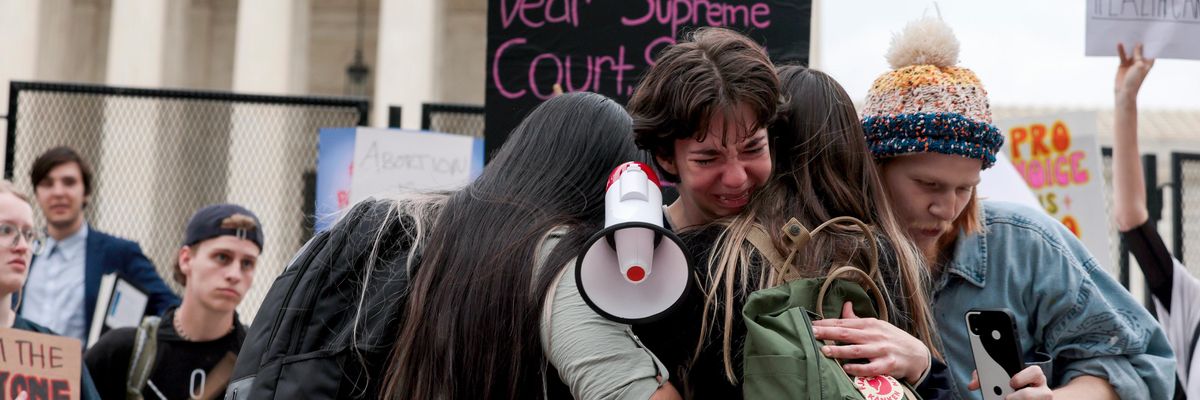 Hannah Yost is embraced by her husband and fellow protesters as she speaks about her experience with sexual assault during an abortion-rights rally