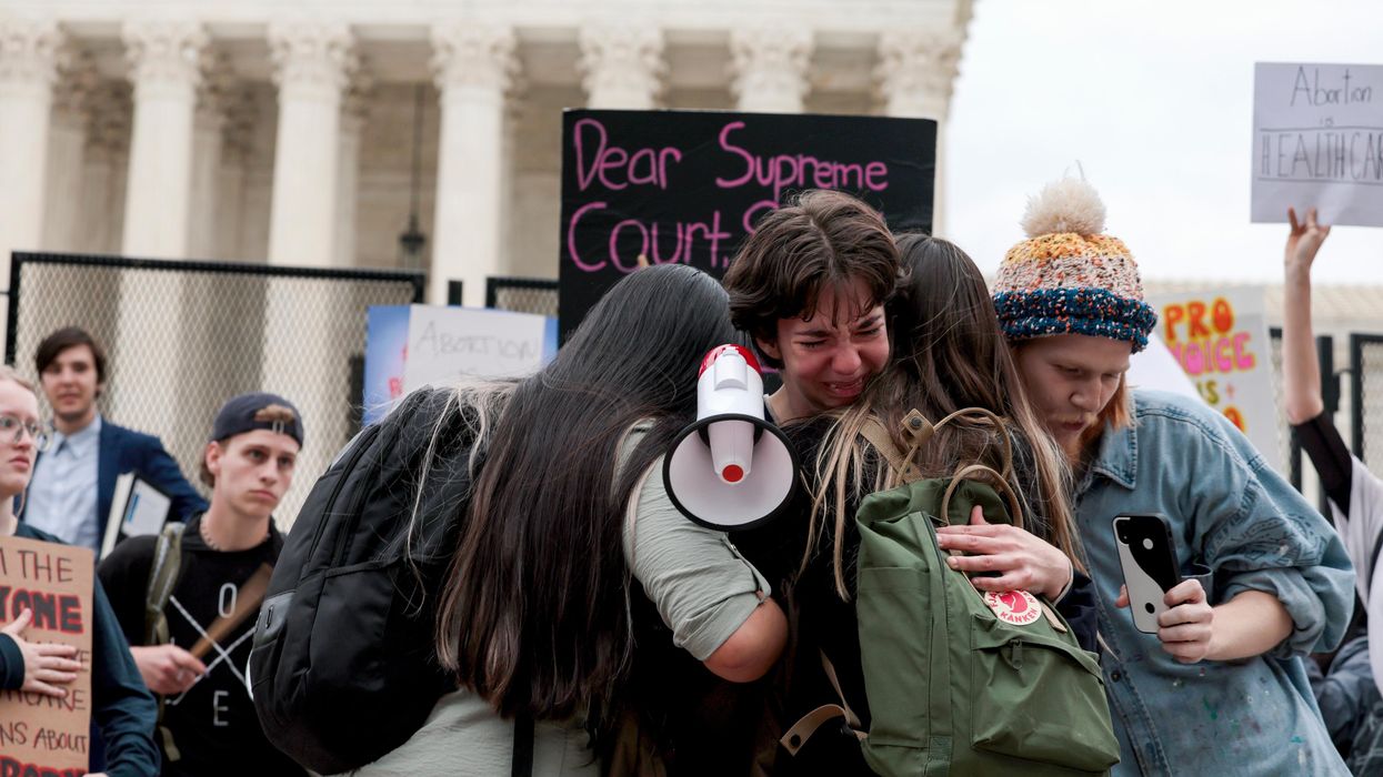 Hannah Yost is embraced by her husband and fellow protesters as she speaks about her experience with sexual assault during an abortion-rights rally
