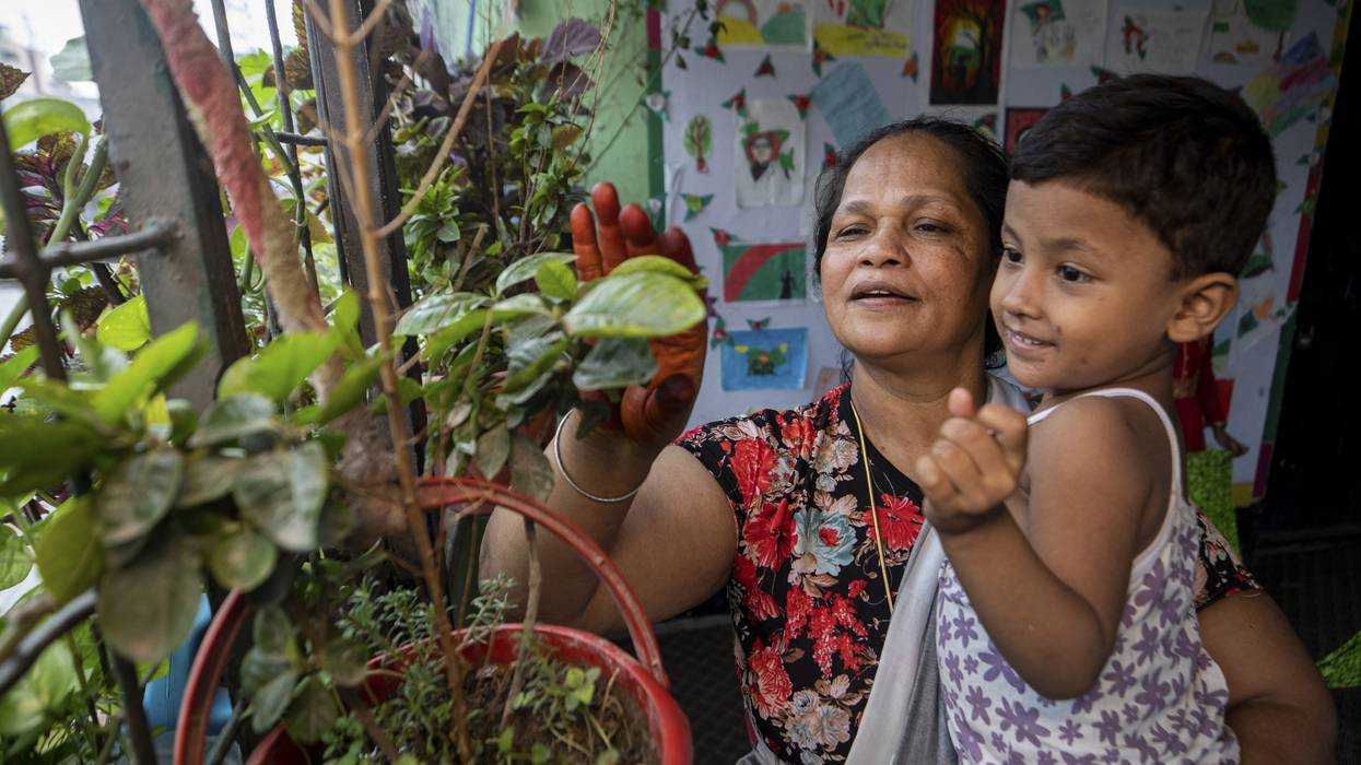 Hazera Begum takes care of children inside her shelter center in Dhaka, Bangladesh on May 8, 2022.