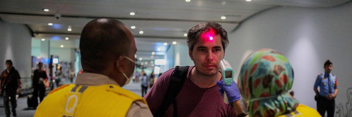 Health officials check the temperature of an arriving passenger to detect possible monkeypox cases at the Soekarno-Hatta International Airport near Jakarta, Indonesia on May 15, 2019.