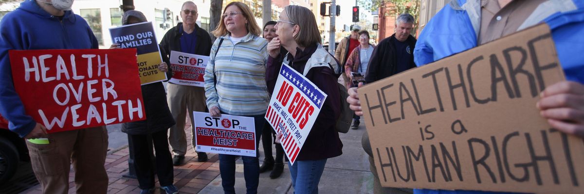 'Health Over Wealth' and 'Healthcare is a Human Right,' signs say