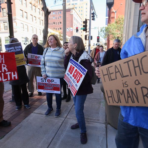 'Health Over Wealth' and 'Healthcare is a Human Right,' signs say