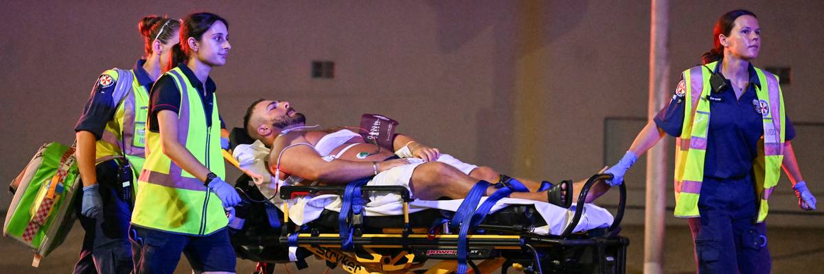 Health workers move a man on a stretcher to an ambulance