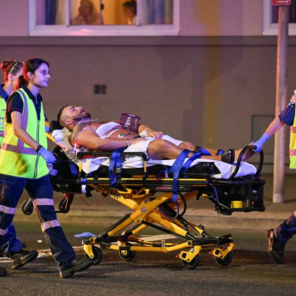 Health workers move a man on a stretcher to an ambulance