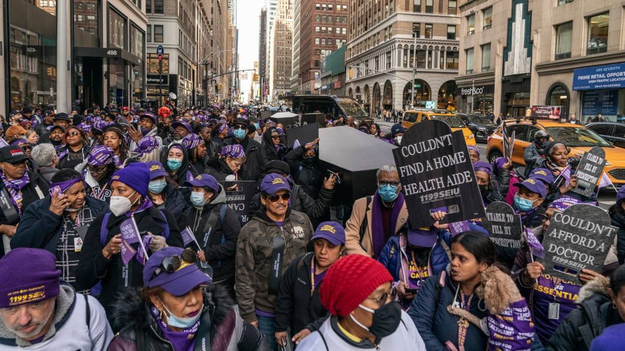 Healthcare workers carry fake coffin during New York protest.