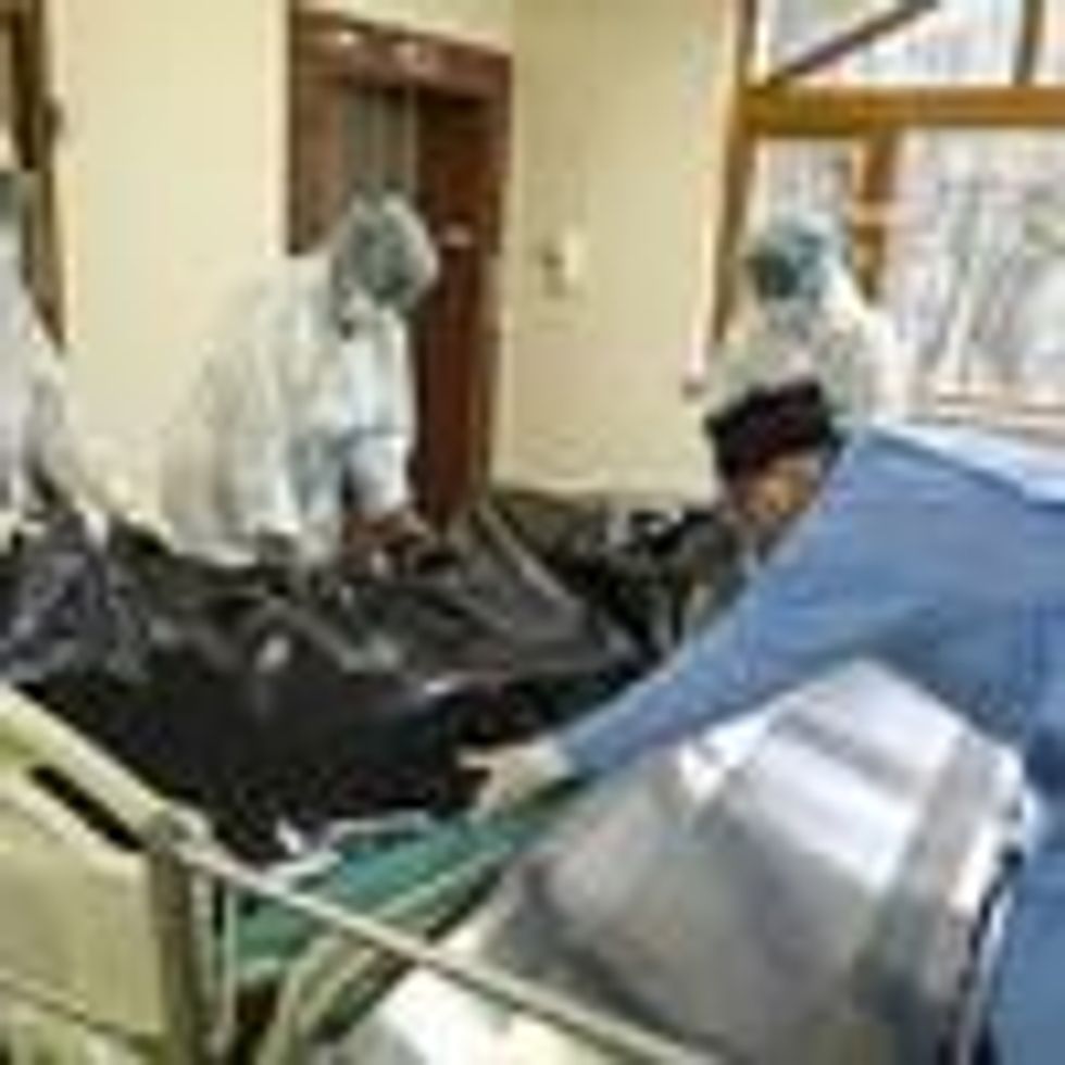 Healthcare workers move the bodybag of a Covid-19 victim.
