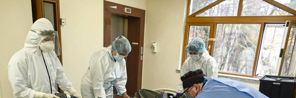 Healthcare workers move the bodybag of a Covid-19 victim.