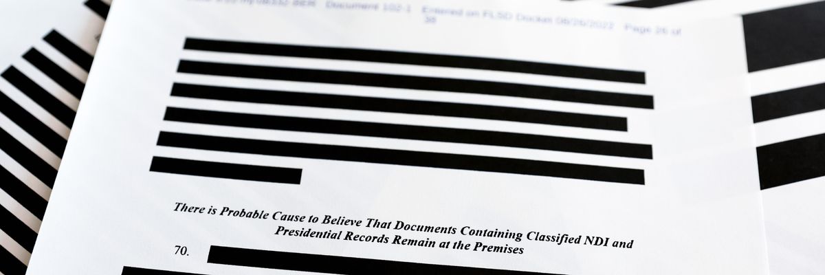 Heavily redacted classified documents are pictured