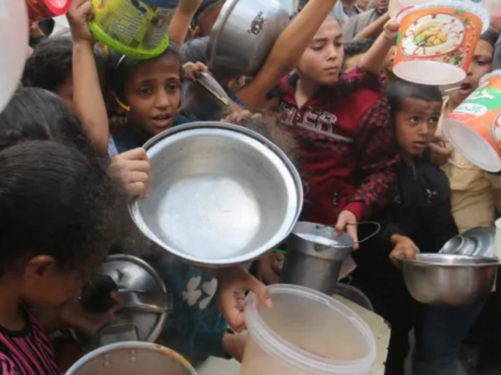 Hungry Palestinian children line up for food in Rafah