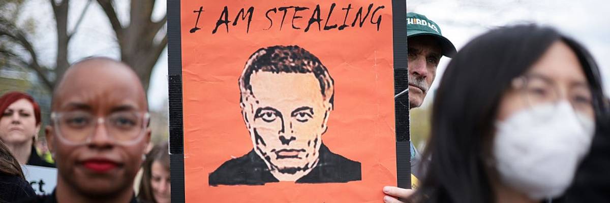 "I am stealing from you," says sign with Elon Musk picture