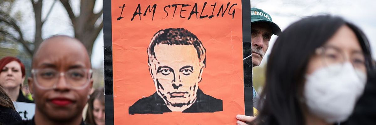"I am stealing from you," says sign with Elon Musk picture
