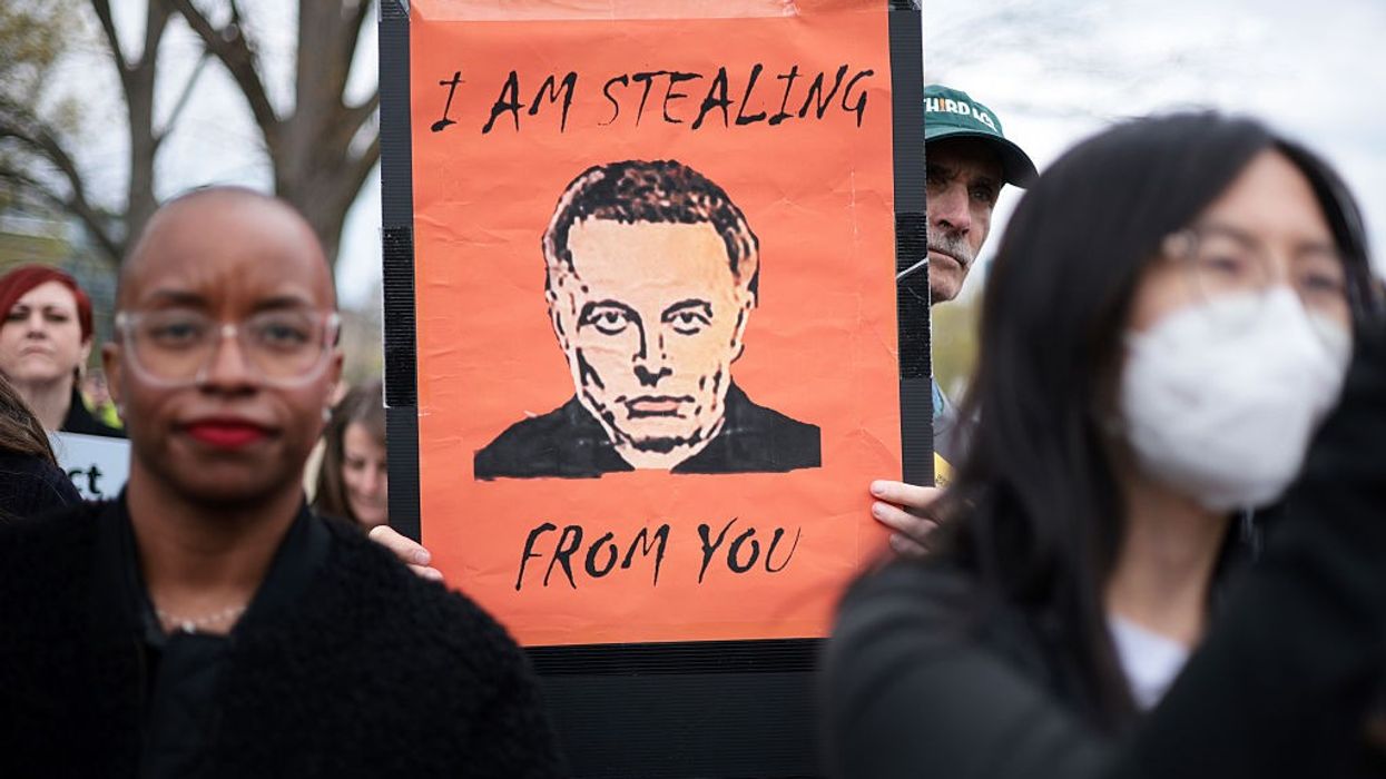 "I am stealing from you," says sign with Elon Musk picture