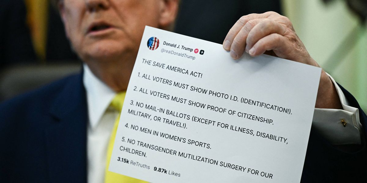 Donald Trump holds up a printout of one of his Truth Social posts