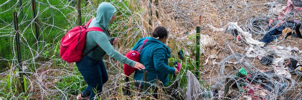 Immigrants pick through coils of razor wire