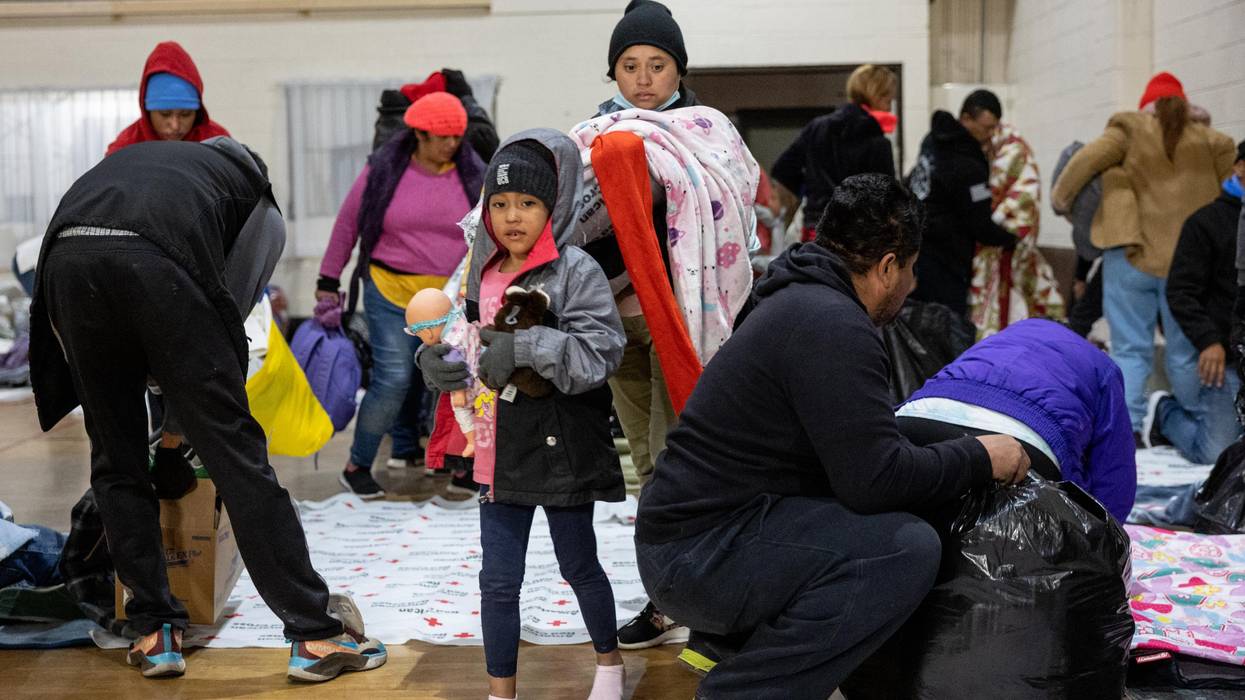 Immigrants prepare to spend the night in a gymnasium shelter