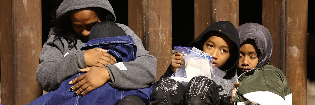 Immigrants seeking asylum in the United States wait as they are processed by U.S. Border Patrol agents in the early morning hours after crossing into Yuma, Arizona from Mexico on May 10, 2023.