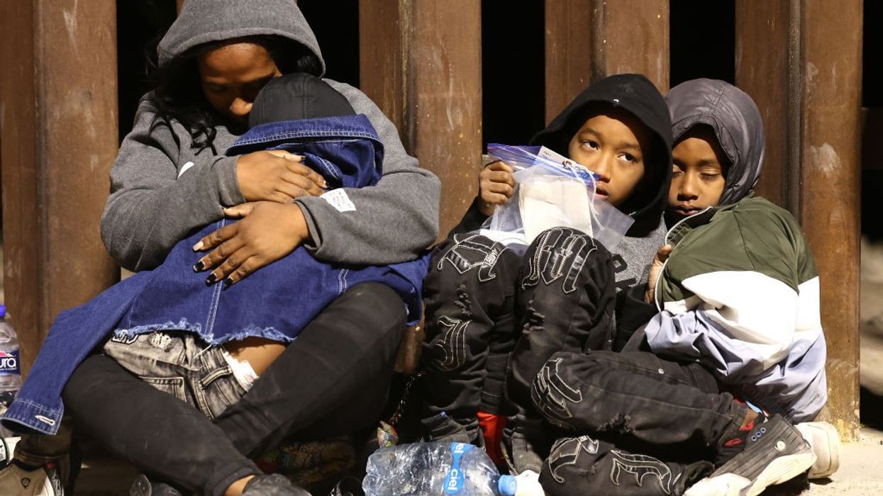 Immigrants seeking asylum in the United States wait as they are processed by U.S. Border Patrol agents in the early morning hours after crossing into Yuma, Arizona from Mexico on May 10, 2023.