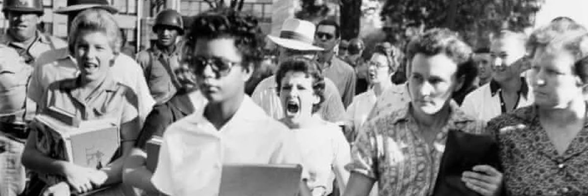 In 1957 Arkansas, a racist crowd taunts and threatens one of nine black students seeking to integrate Little Rock High School.  