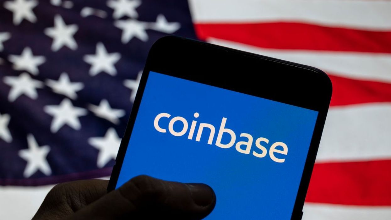 In this photo illustration, the logo of Coinbase, an online platform for buying, selling, transferring, and selling cryptocurrency, is seen on an Android device with the U.S. flag.