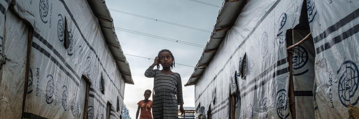 Internally displaced children run in an alley of a camp in the town of Azezo, Ethiopia