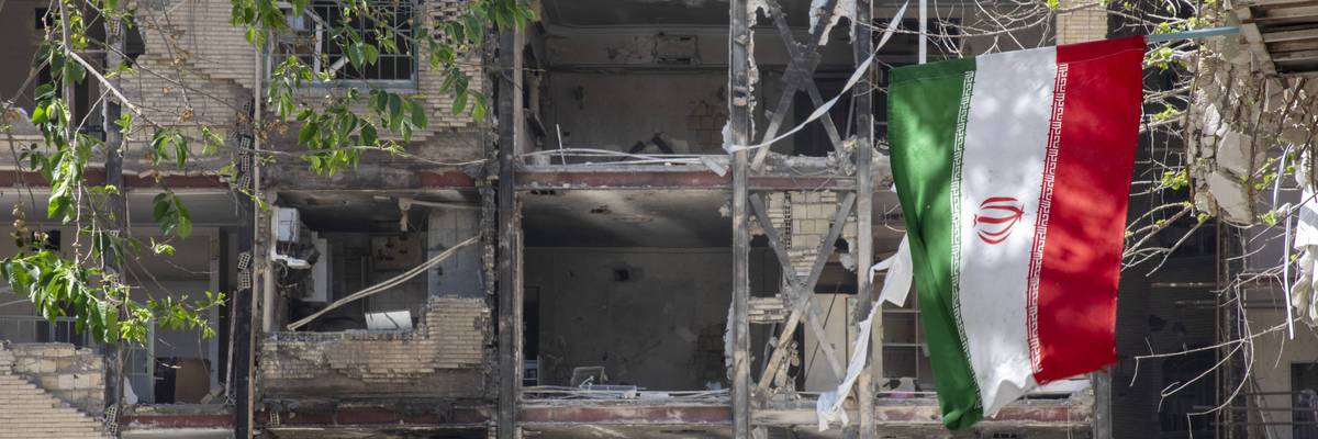Iranian flag hangs from damaged building following US strikes