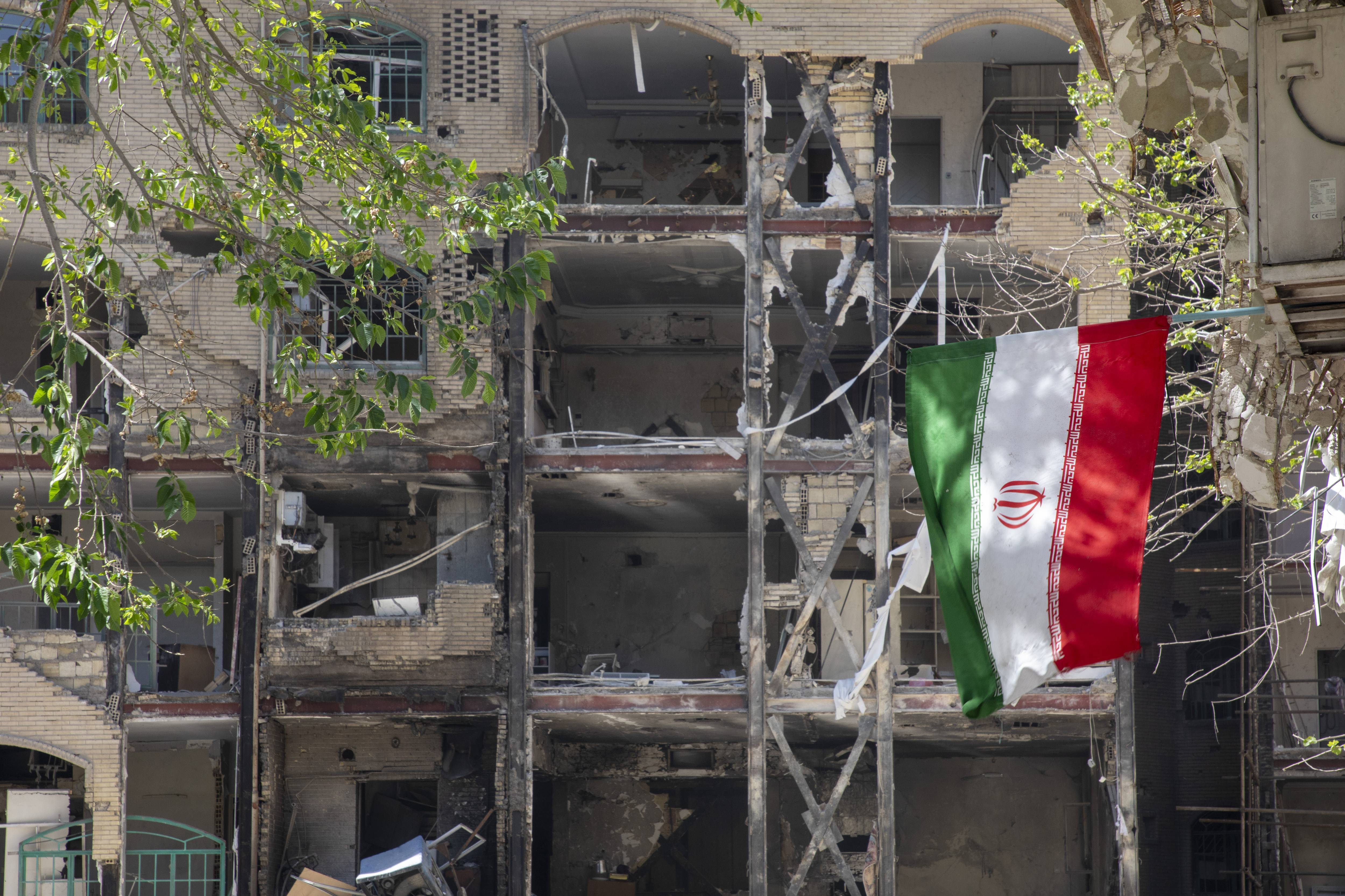 Iranian flag hangs from damaged building following US strikes